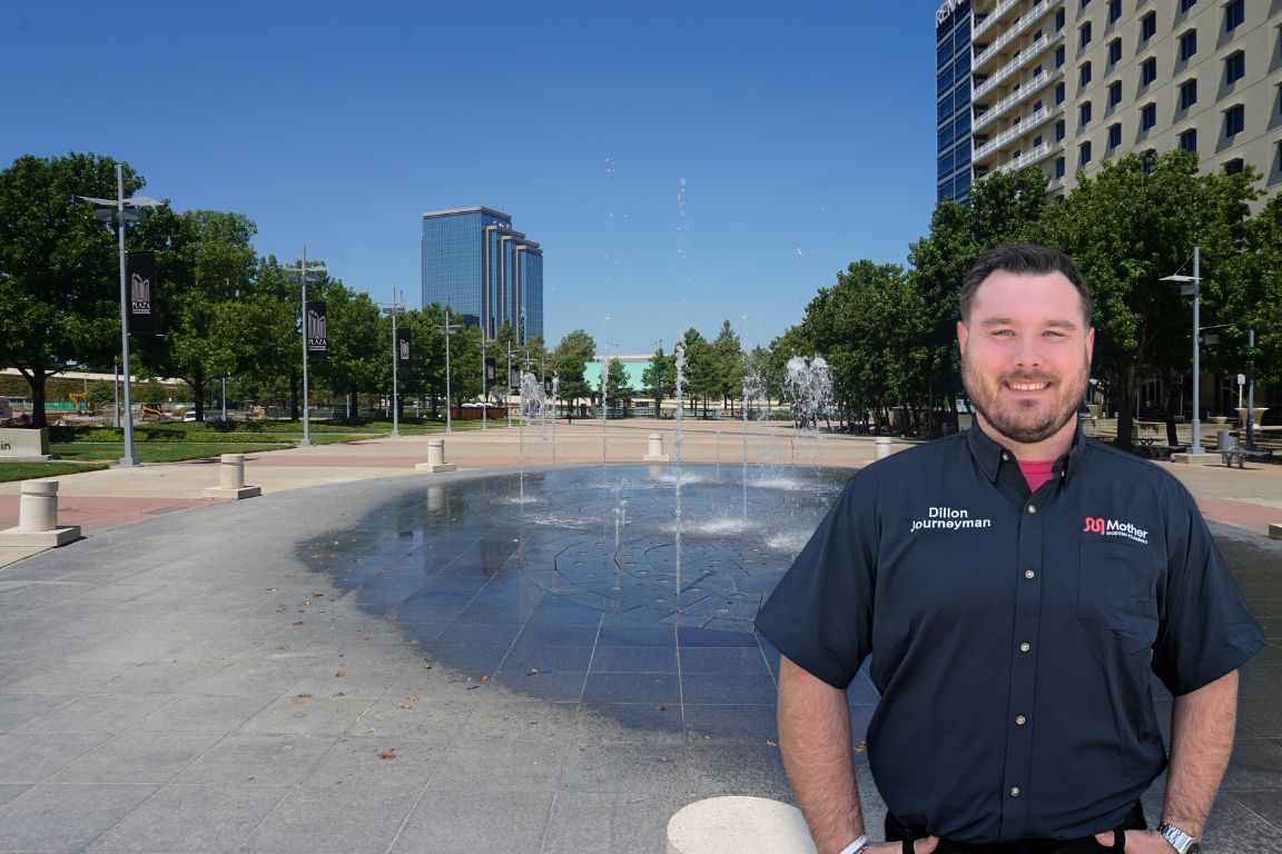 Photo of a uniformed plumber in Richardson, TX from Mother Modern Plumbing standing and smiling
