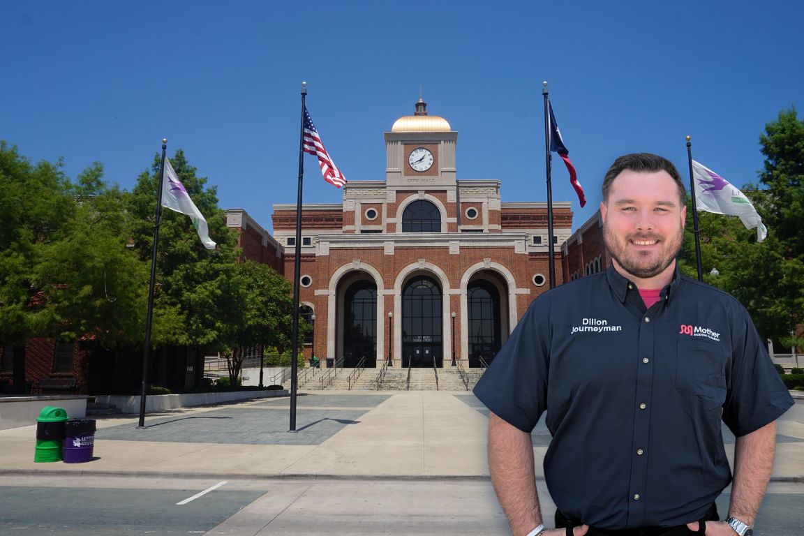Photo of a uniformed plumber in Lewisville, TX from Mother Modern Plumbing standing and smiling