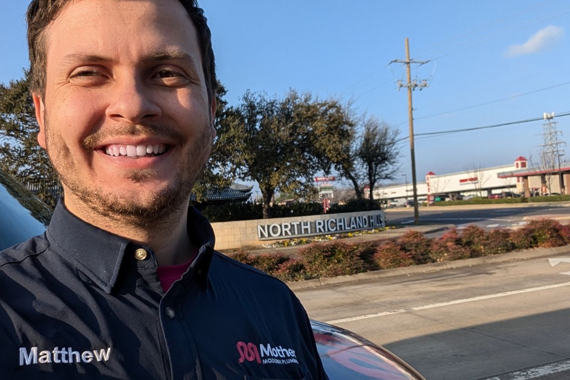 Photo of a uniformed plumber in North Richland Hills, TX from Mother Modern Plumbing standing and smiling