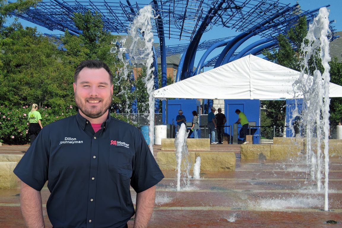 Photo of a uniformed plumber in Addison, TX from Mother Modern Plumbing standing and smiling