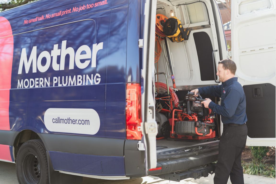 Photo of a uniformed plumber in Haltom City, TX from Mother Modern Plumbing standing and smiling