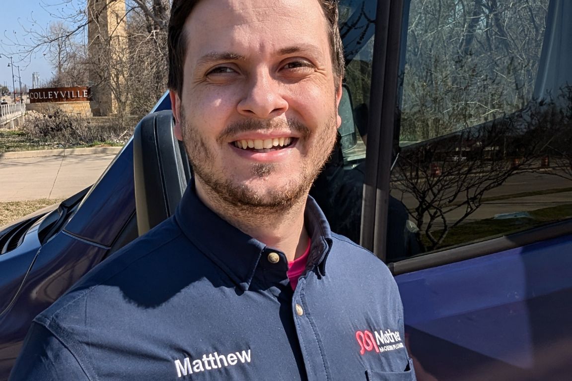 Photo of a uniformed plumber in Colleyville, TX from Mother Modern Plumbing standing and smiling