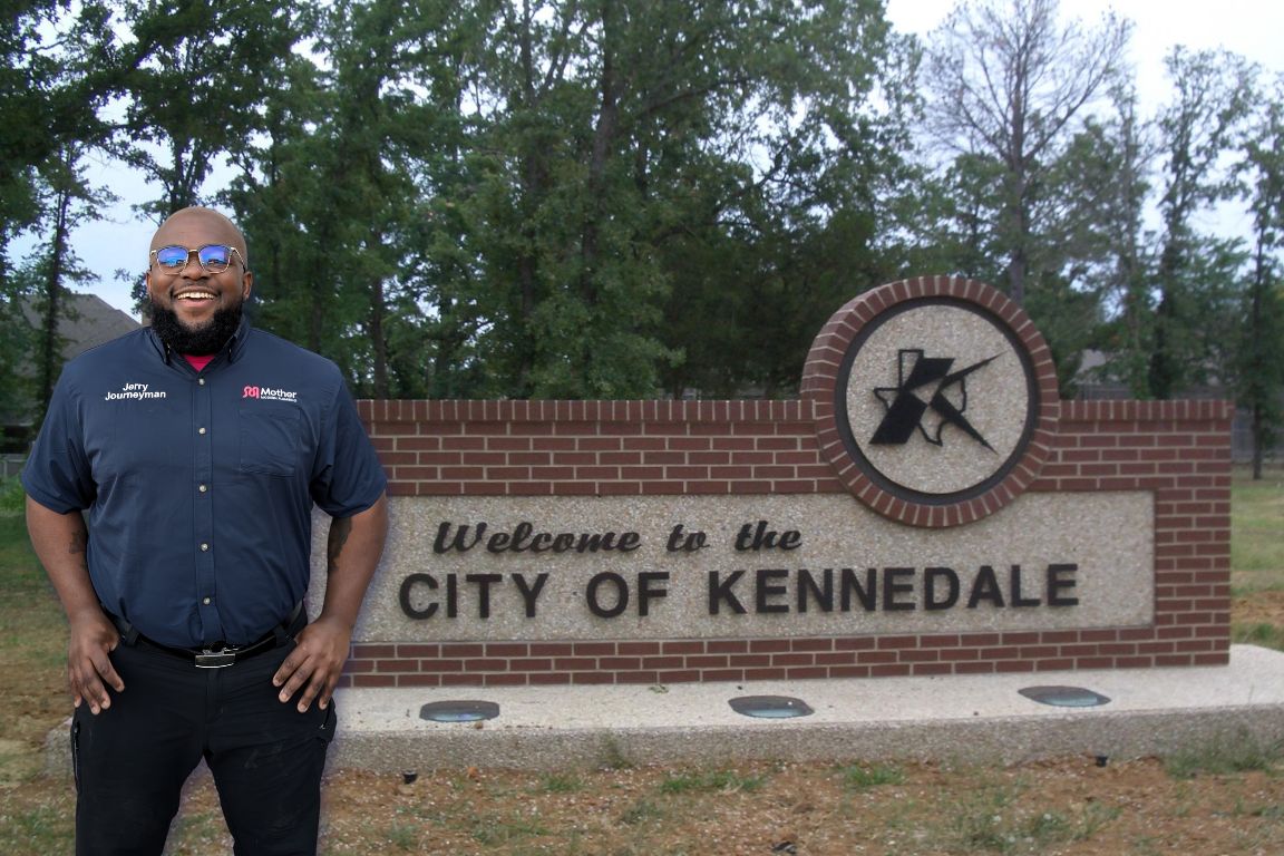 Photo of a uniformed plumber in Kennedale, TX from Mother Modern Plumbing standing and smiling