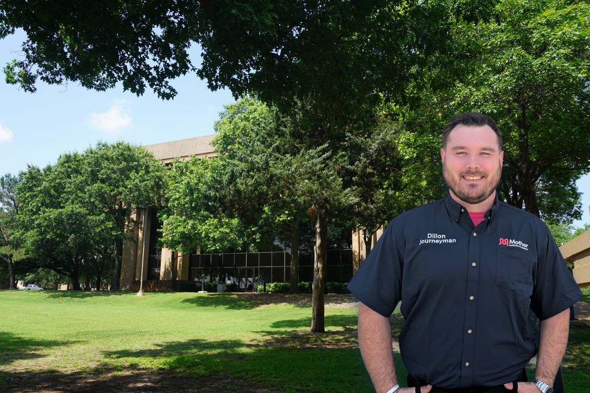 Photo of a uniformed plumber in Irving, TX from Mother Modern Plumbing standing and smiling