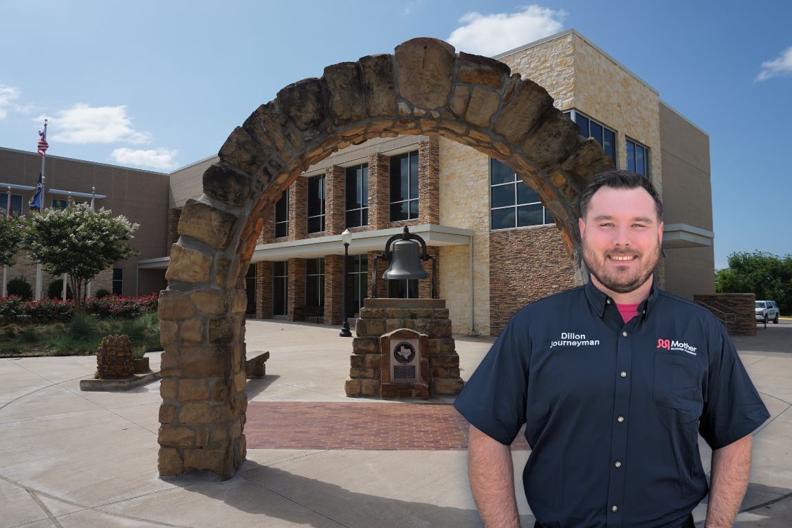 Photo of a uniformed plumber in Weatherford, TX from Mother Modern Plumbing standing and smiling
