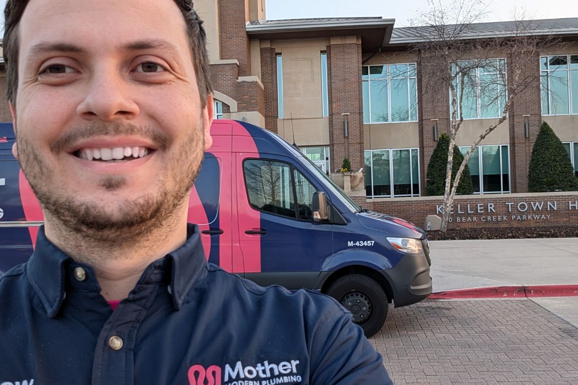 Photo of a uniformed plumber in Keller, TX from Mother Modern Plumbing standing and smiling