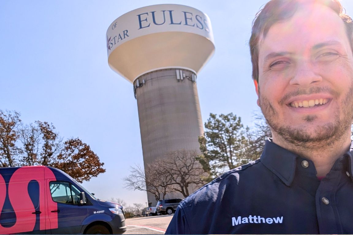 Photo of a uniformed plumber in Euless, TX from Mother Modern Plumbing standing and smiling