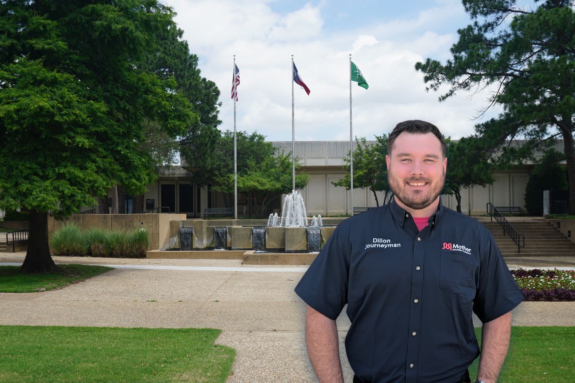 Photo of a uniformed plumber in Grand Prairie, TX from Mother Modern Plumbing standing and smiling