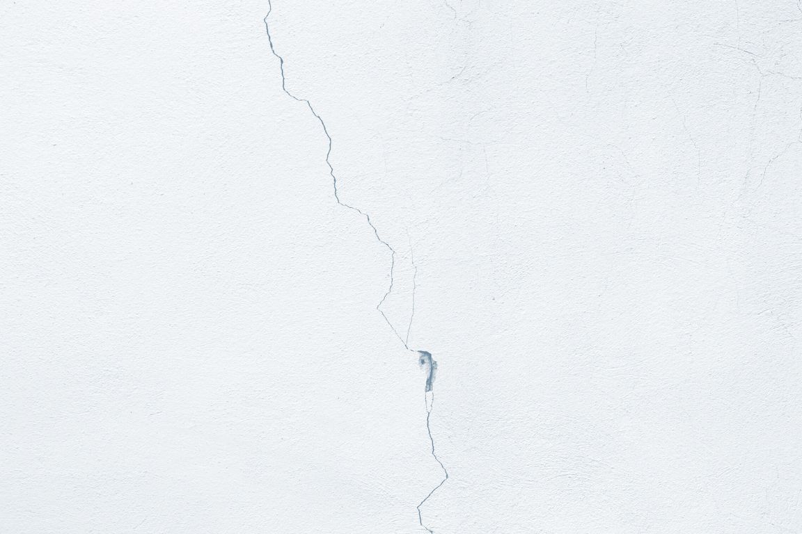 damp crack in drywall caused by slab leak underneath home