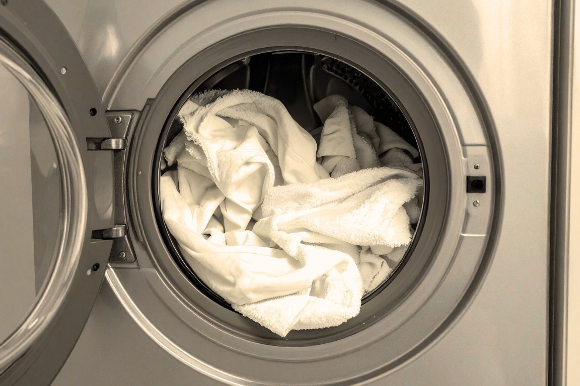 load of laundry in washing machine showing faded whites from hard water