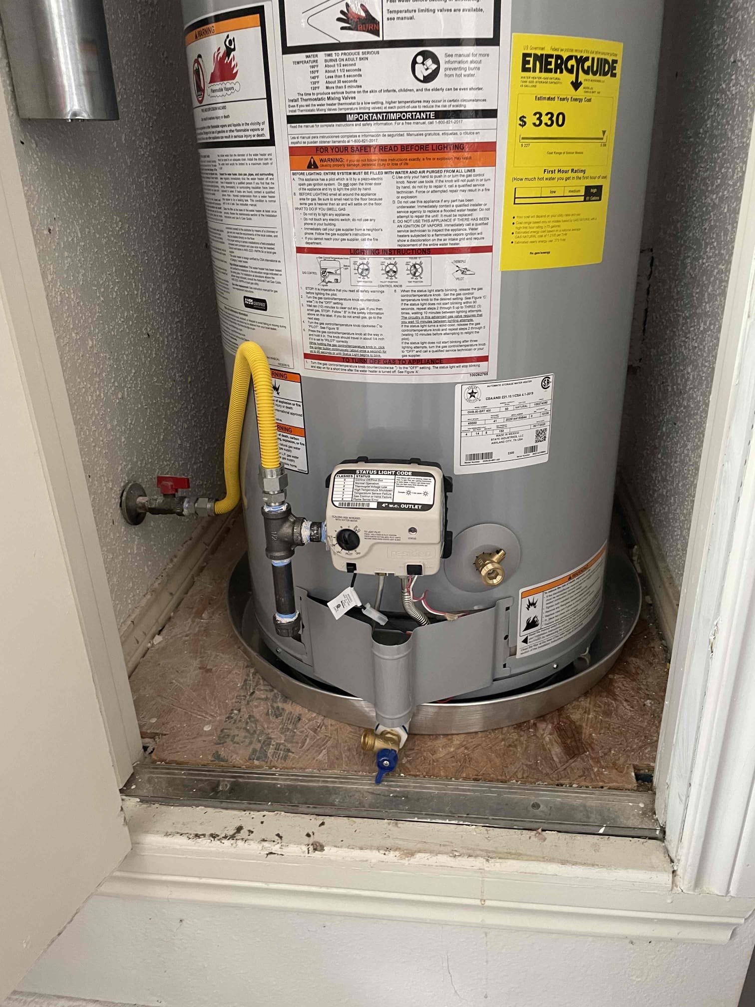 A tank water heater from the state pro line that Mother Installed in a frisco home. You can see a yellow natural gas line coming into the heater. 