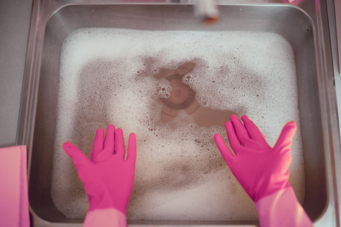 woman standing over slow draining sink as symptom of a sewer line collapse