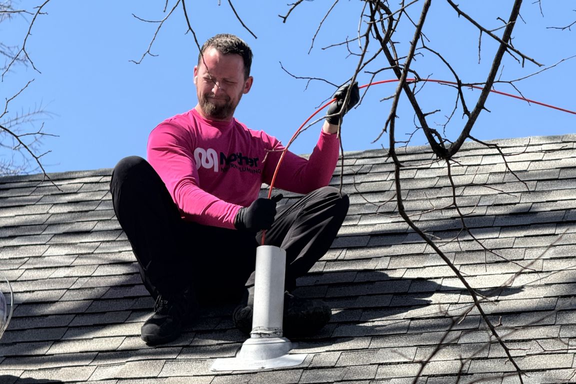 Master Plumber using auger to clean sewer vent pipe on roof of fort worth, tx home, mother modern plumbing