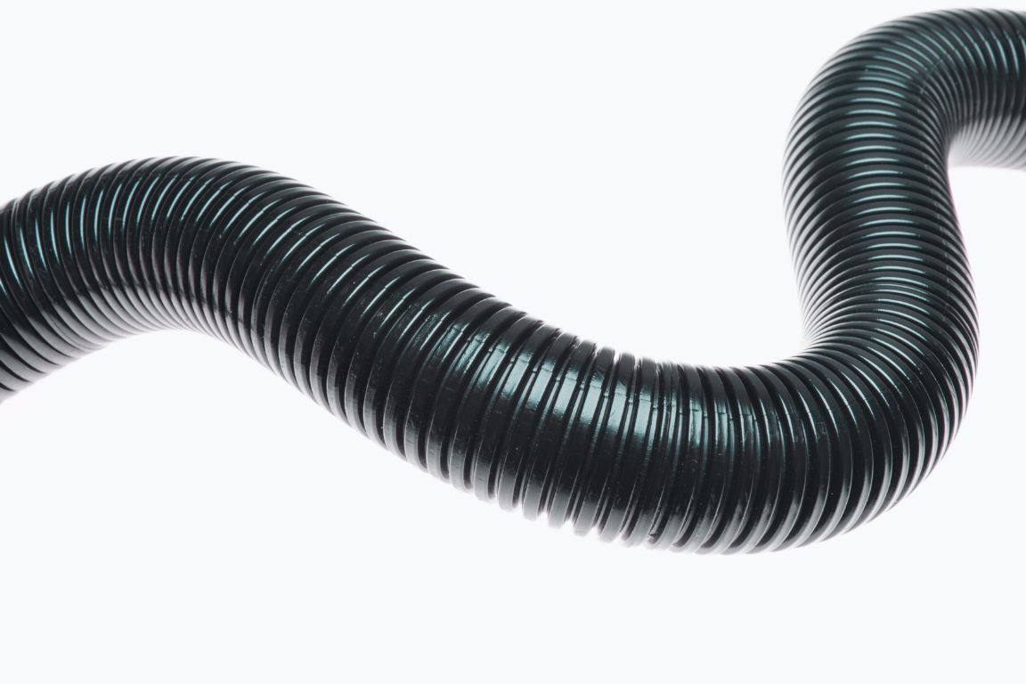 black corrugated pipe with accordion like ribs that trap debris and grease