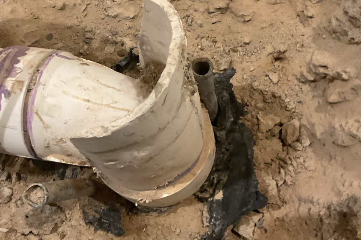 broken pvc pipe in the backyard clay soil of an azle, tx, home