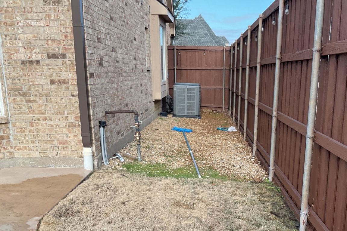 a strip of green grass within a dead lawn, in a straight line over the main water supply line, indicating a north texas leak