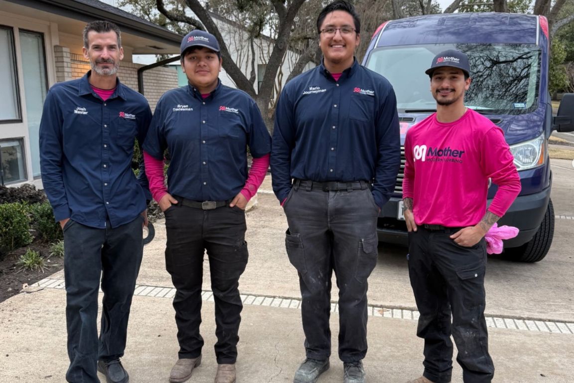 four plumbers from mother modern plumbing stand in front of service van at preston hollow, tx home
