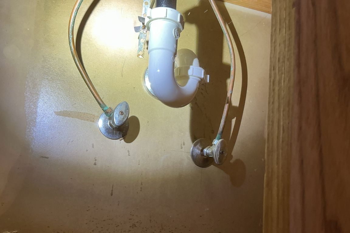 hot and cold water shut-off valves installed under kitchen sink cabinetry in DFW kitchen, mother modern plumbing