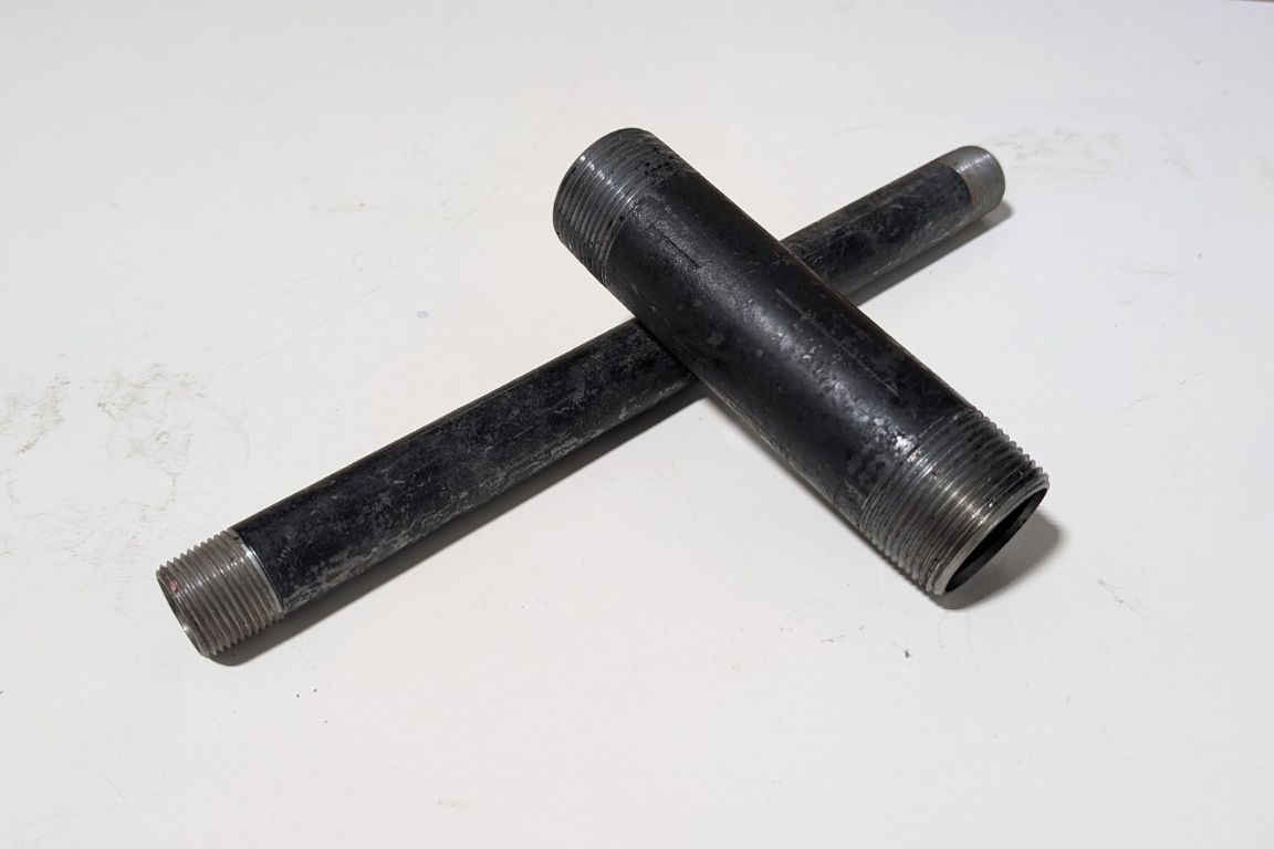 two sections of black iron pipe of different widths, cut at cross sections with one threaded end