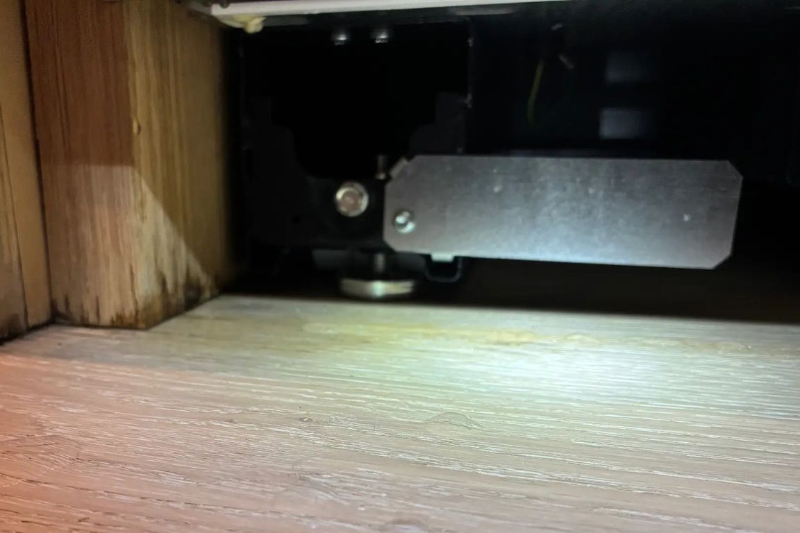 small pool of water outside refrigerator door with unclear source