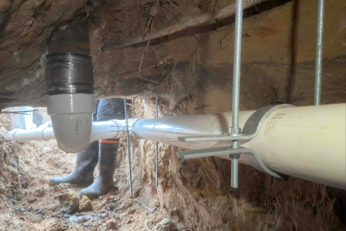 view inside excavated trench showing new schedule 40 pvc sewer line installation
