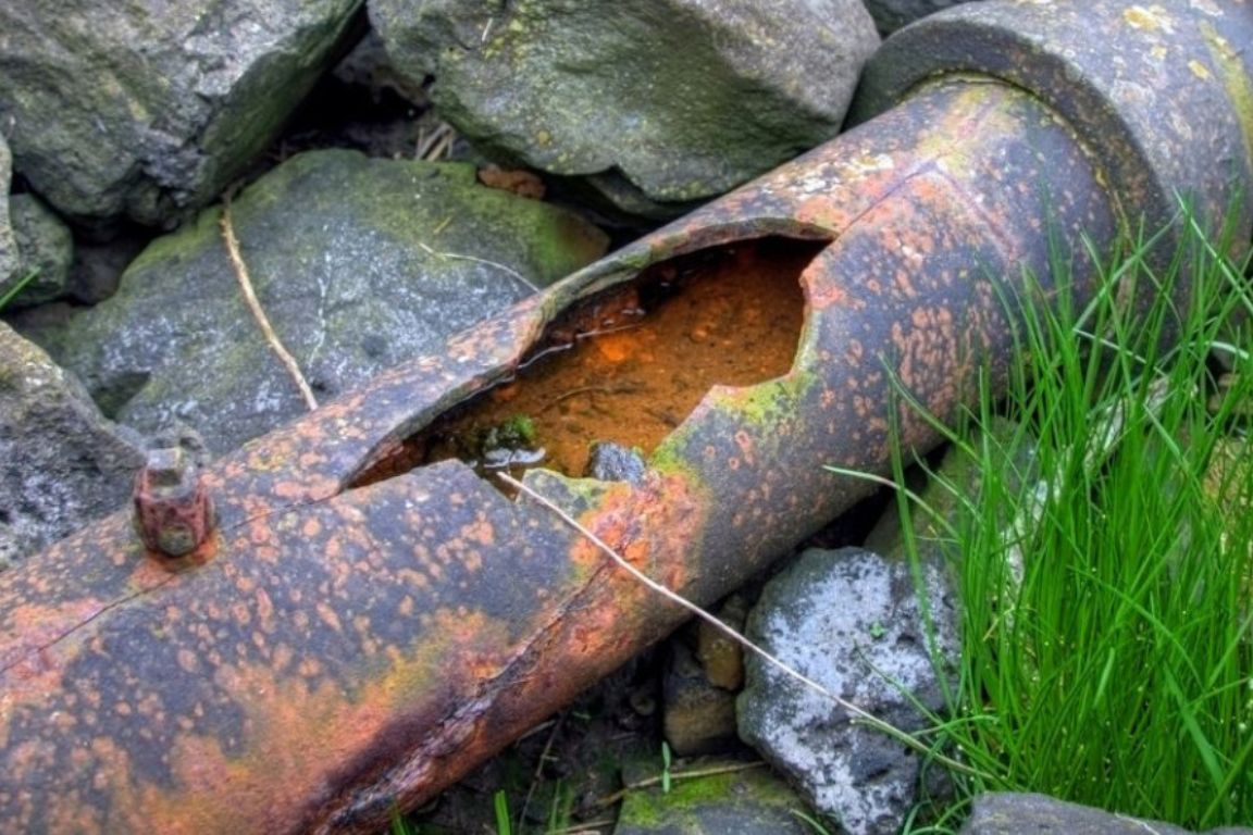 section of cast iron sewer pipe affected by severe channel rot and rust with 18" crack in pipe
