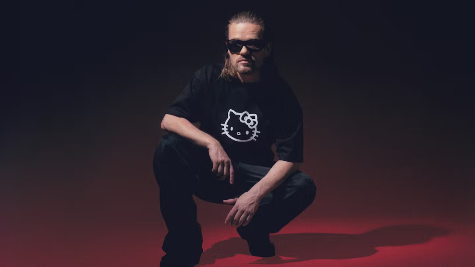 Rune rask sidder på hug med solbriller på