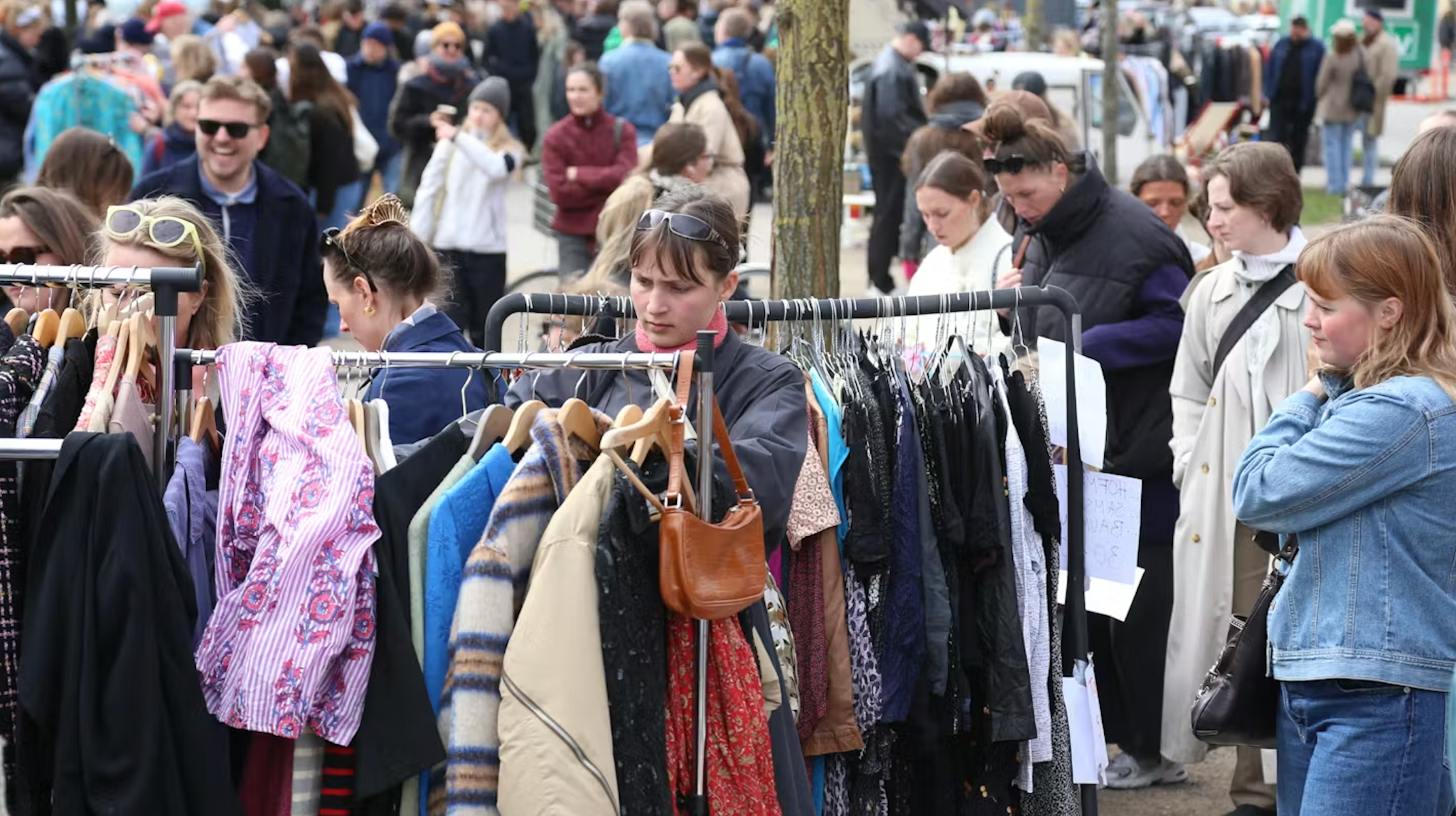Besøgende på et udendørs loppemarked med tøj