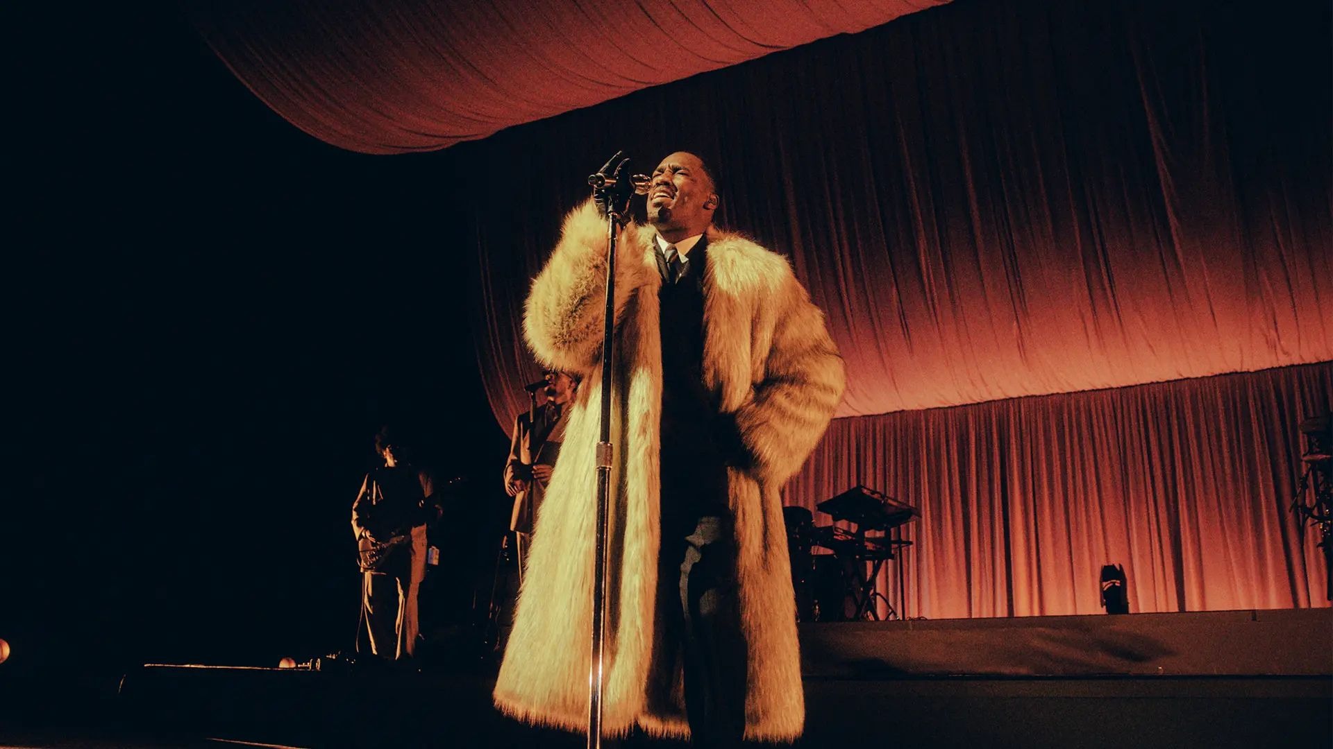 Giveon på scenen i en stor pelsfrakke