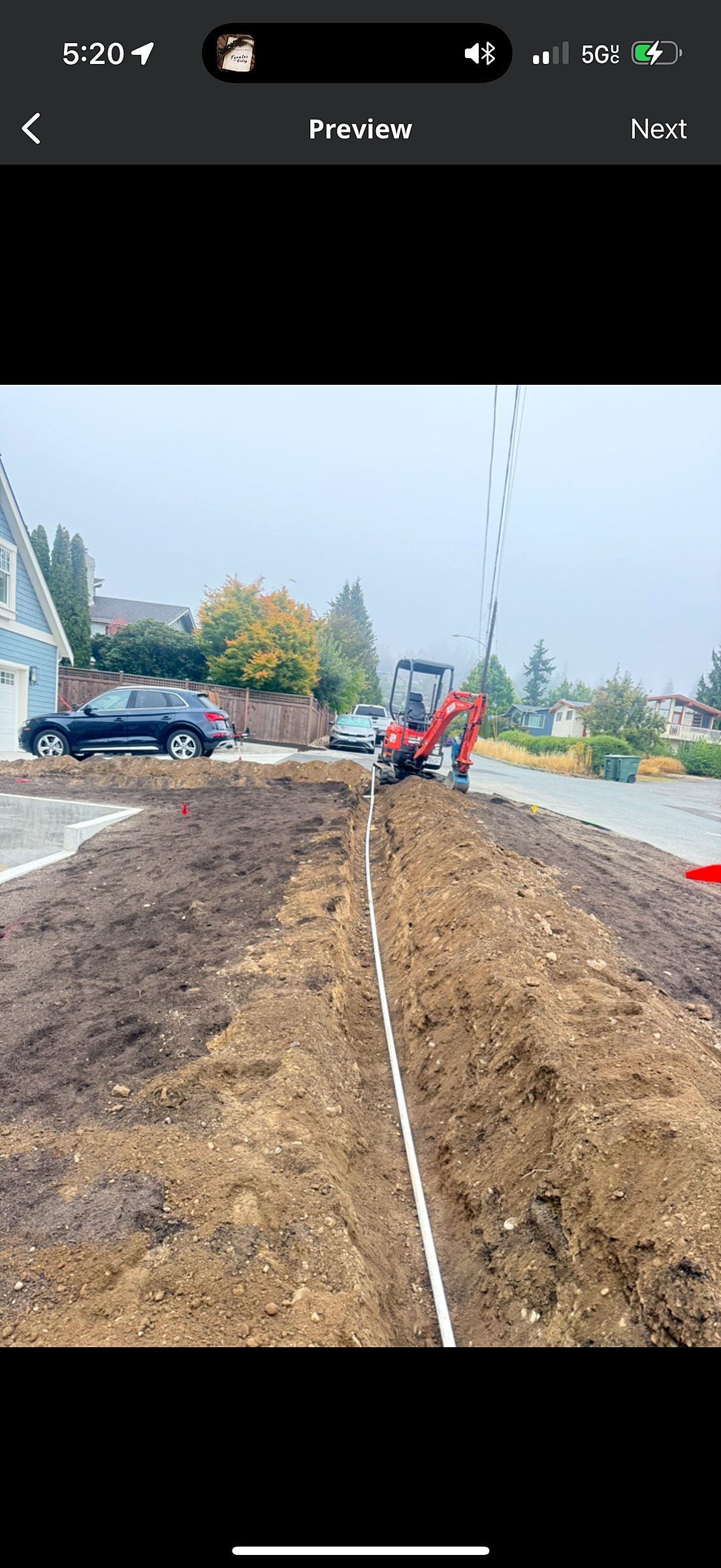 Excavated trench with perforated drain pipe installed by Grizzly
