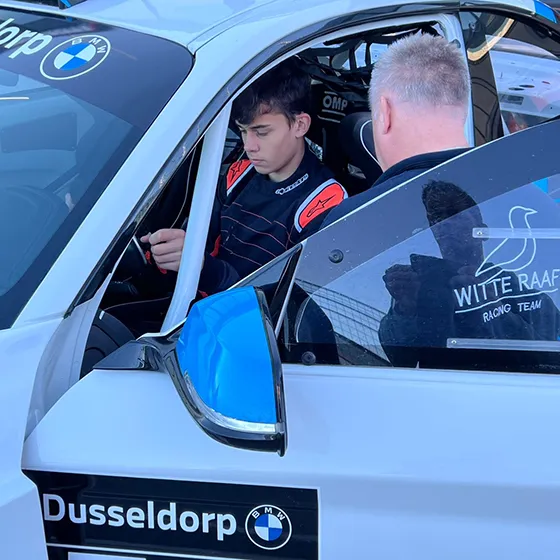 Photo of Riemer sitting in his BMW with a mechanic