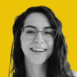 A woman with glasses smiling at the camera.