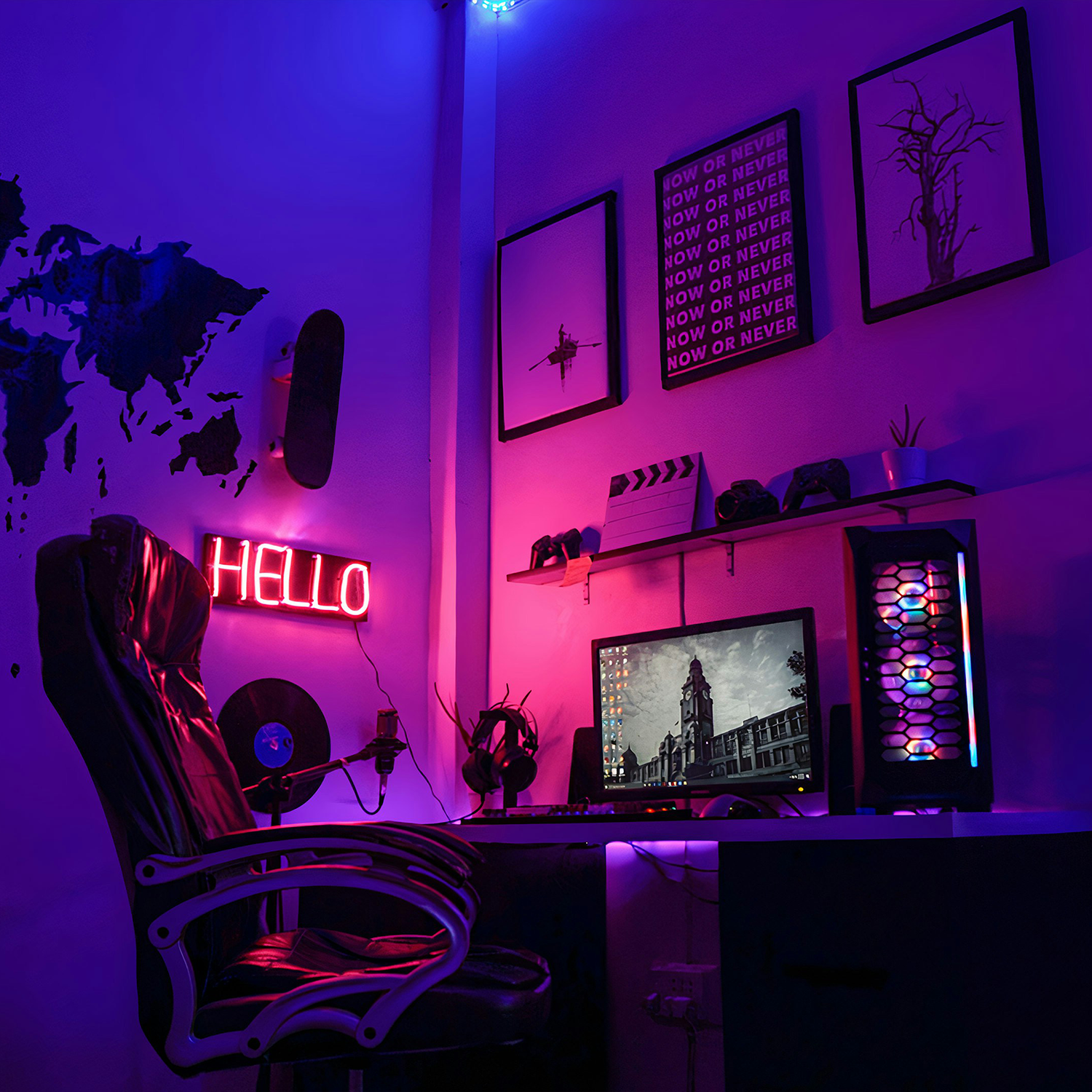 Gaming setup with a black leather chair, desktop computer with colorful LED lights, a monitor displaying a building, and neon 'HELLO' sign on the wall under blue and pink lighting.