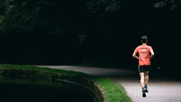 person in red shirt standing near river during daytime
