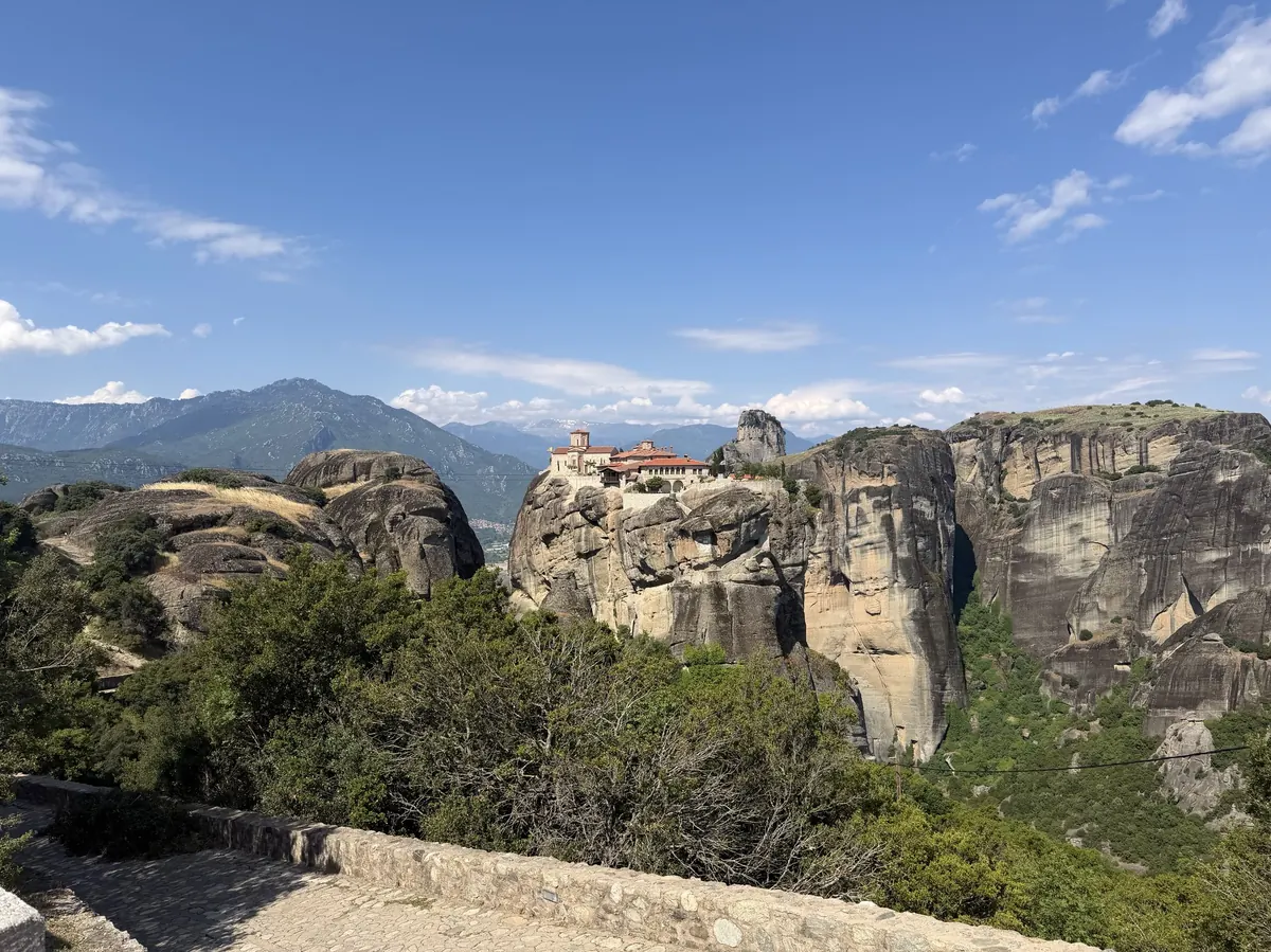 Meteora monastery on the rocks with the green valley stretching beyond