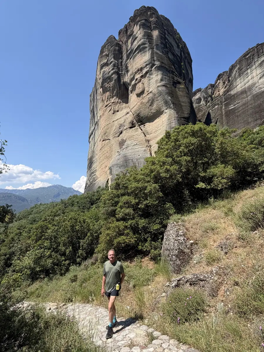 A guest standing among the towering sandstone pillars of Meteora