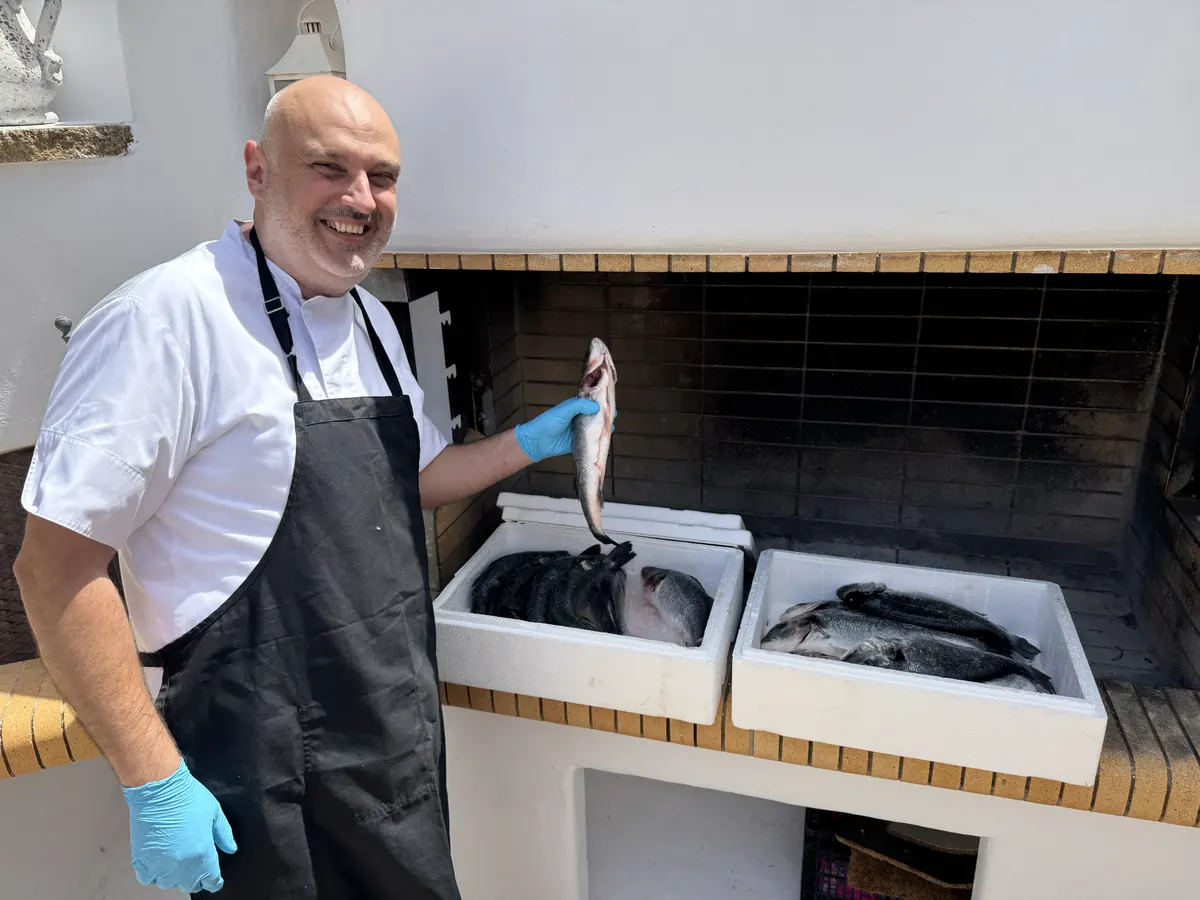 The chef holding up the day's catch in the estate kitchen