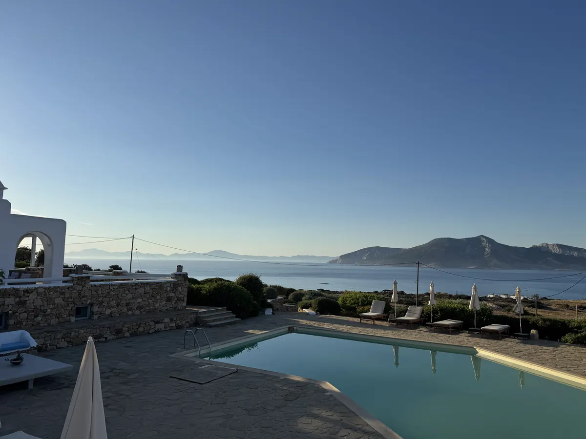 The estate pool at dusk with the sea and islands beyond