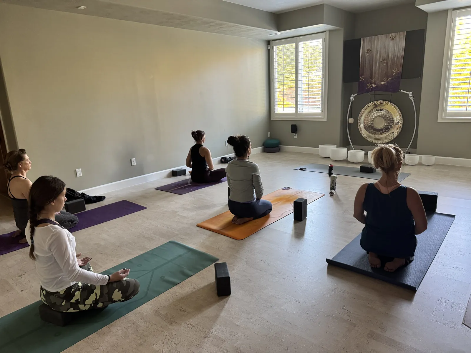 A small seated class at the YogaSoul shala in East Millcreek, gong and bowls at the front