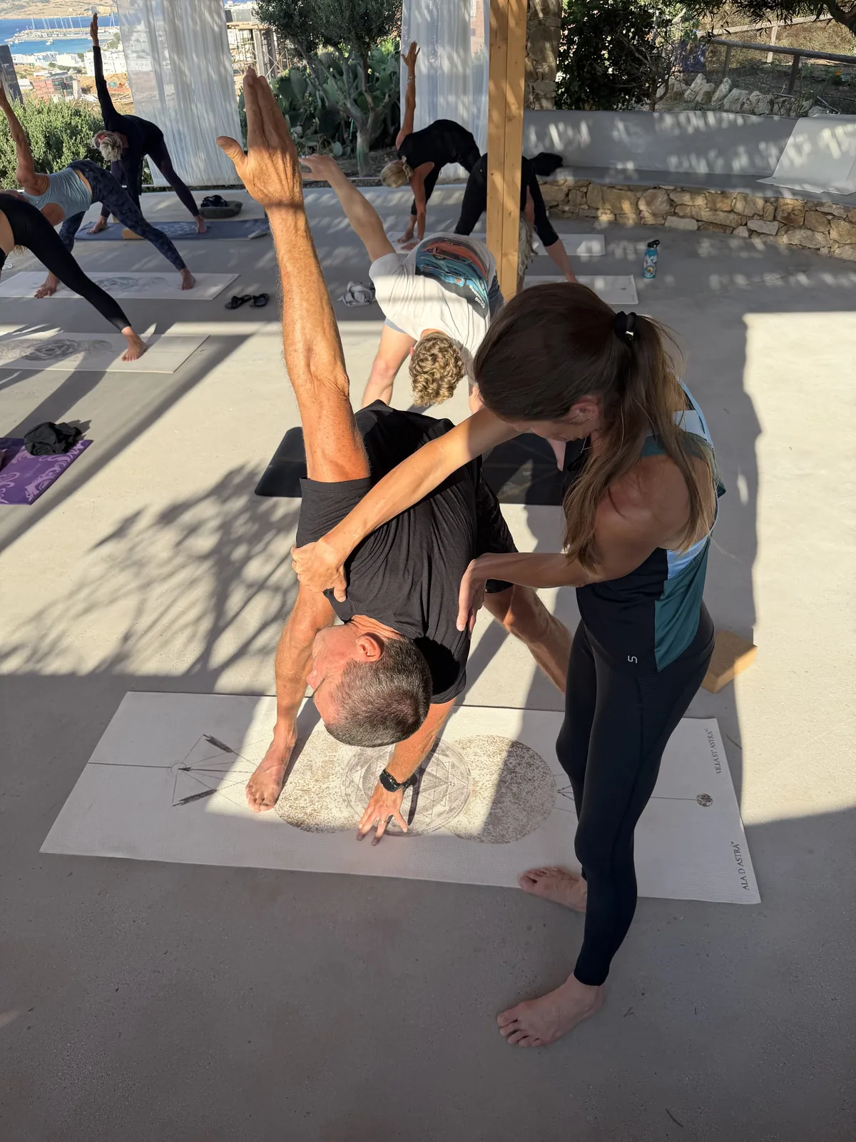Rachel Cieslewicz refining a student’s standing twist, hands on