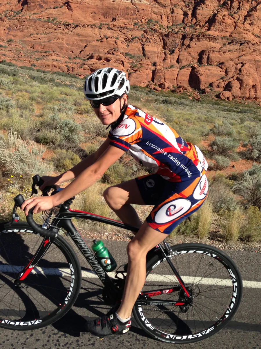 Rachel Cieslewicz road cycling through red rock desert in southern Utah