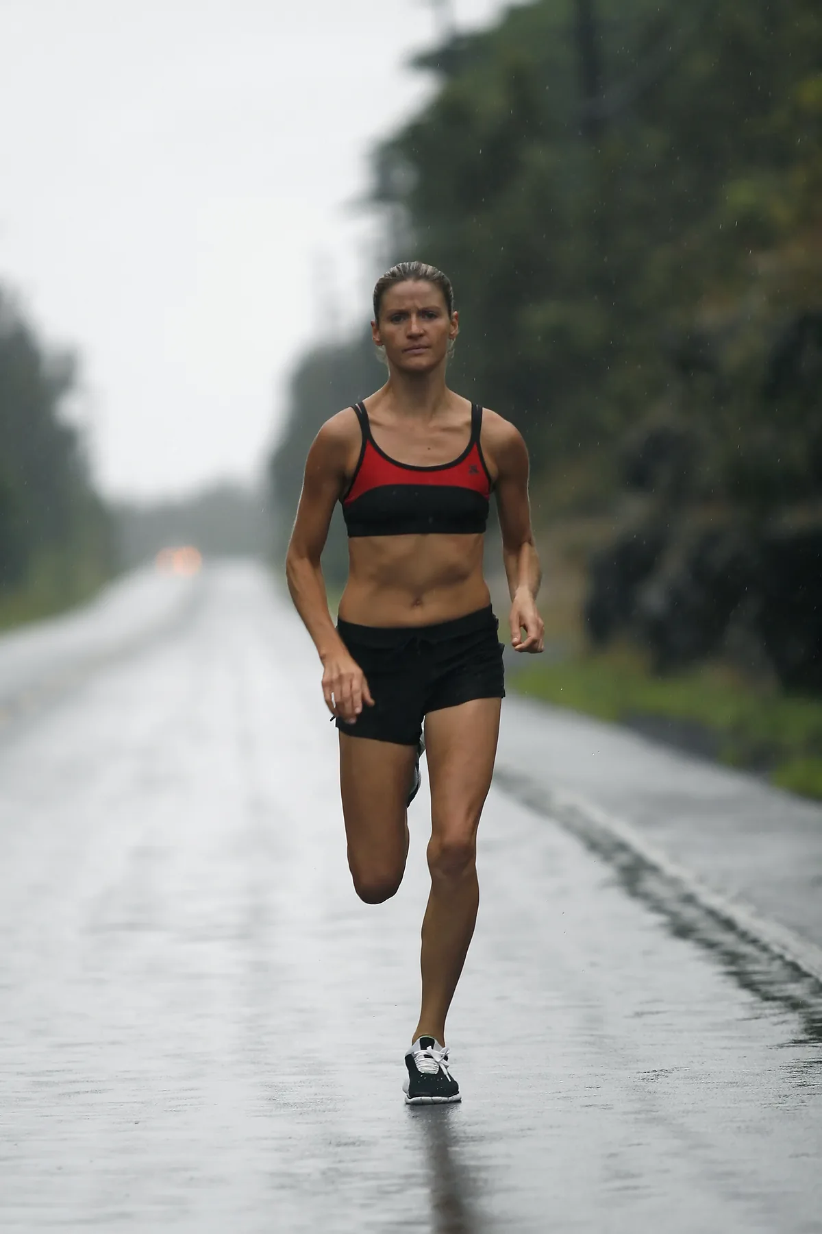 Rachel Cieslewicz running a wet road in the rain