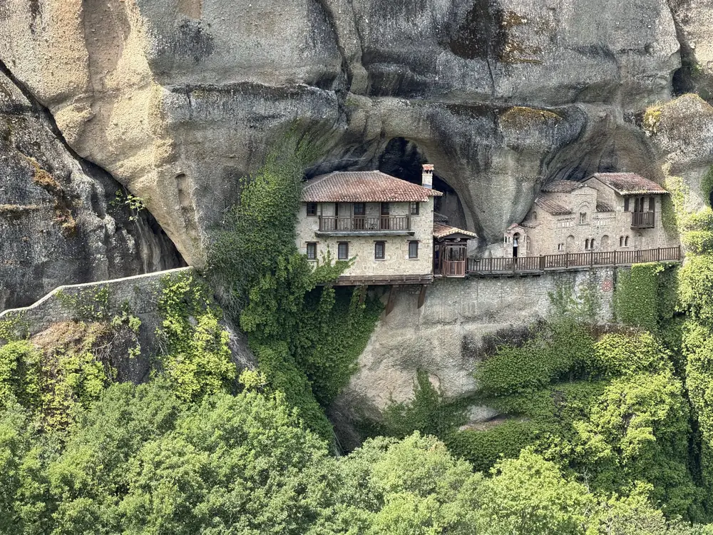 A monastery built directly into the hollow of a cave face