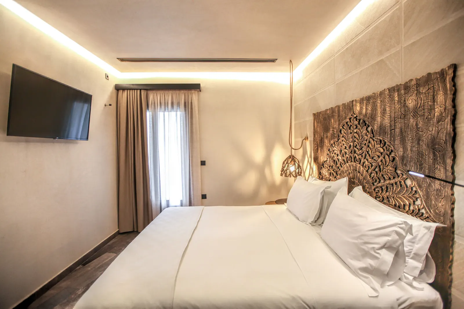 A suite bedroom with a carved wooden headboard