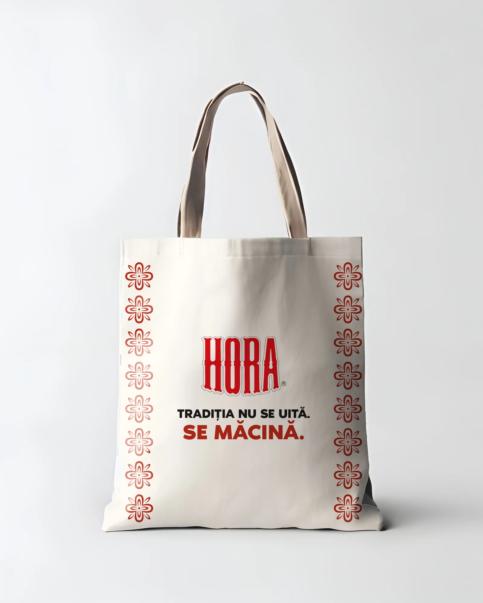 HORA canvas tote bag with red folk-embroidery borders and the line 'Tradiția nu se uită. Se macină.'