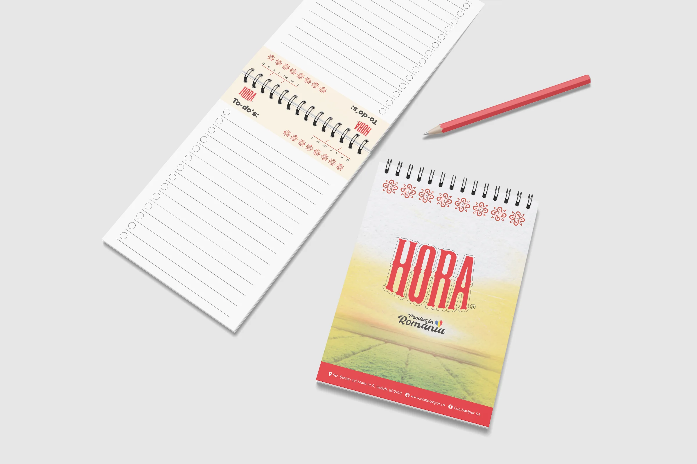 Two HORA notepads on a light grey surface with a red pencil: a lined to-do pad with an embroidery header and a pad with the HORA wordmark over a field.