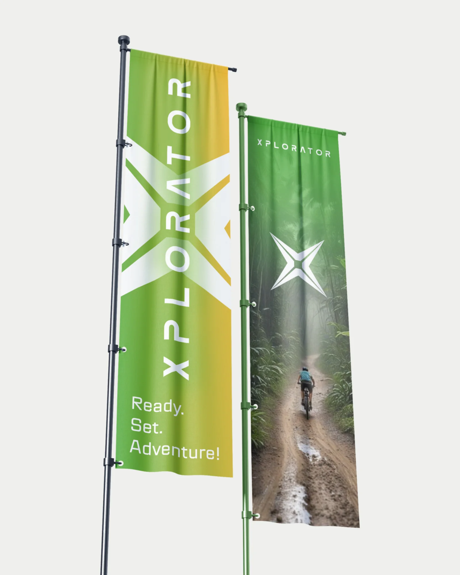 Two Xplorator street flags against a light background: the gradient flag with the wordmark and 'Ready. Set. Adventure!', and the jungle-trail flag with the X-star.