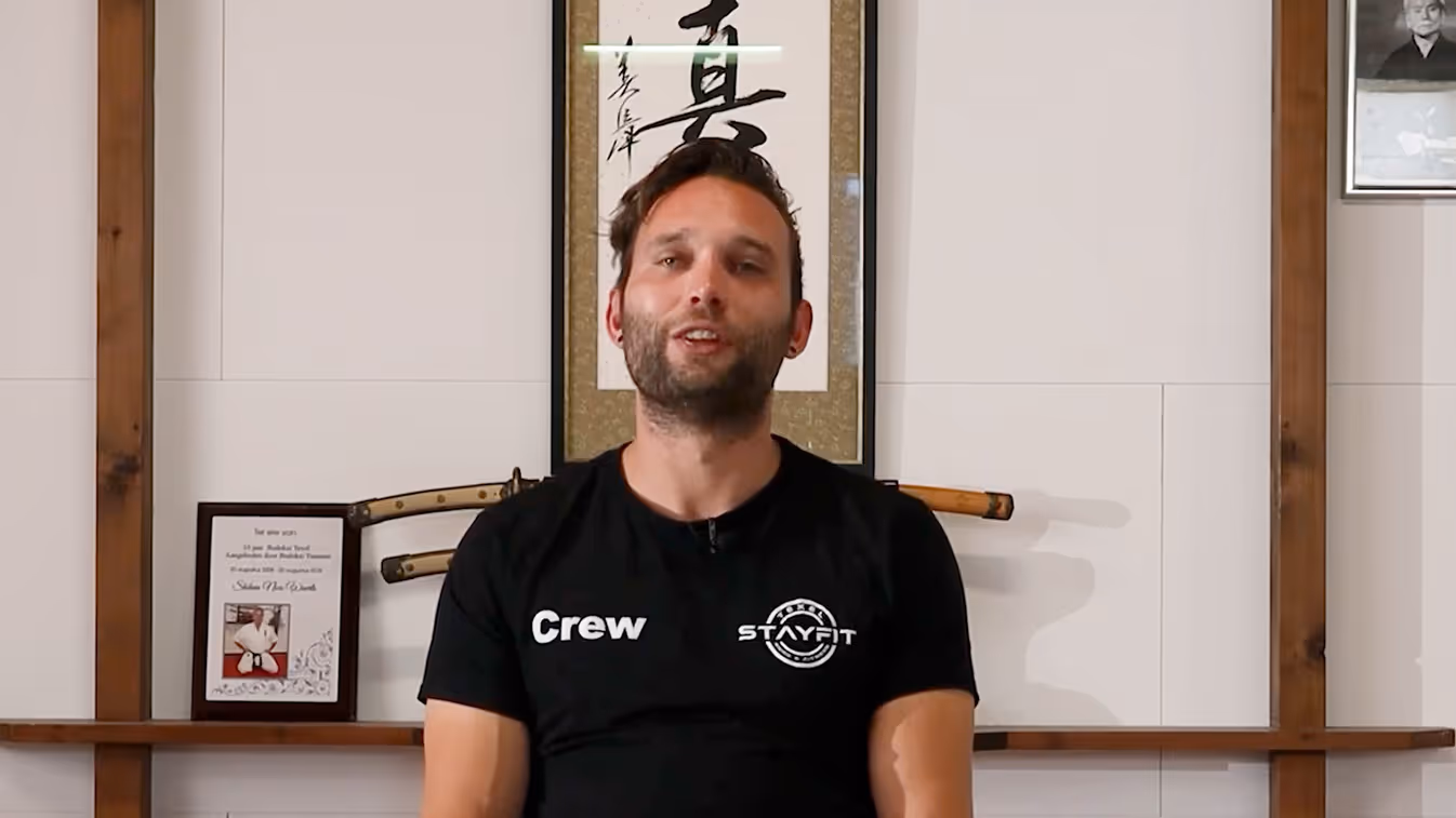 Persoon in crew-shirt voor Japanse kalligrafie en houten wapens