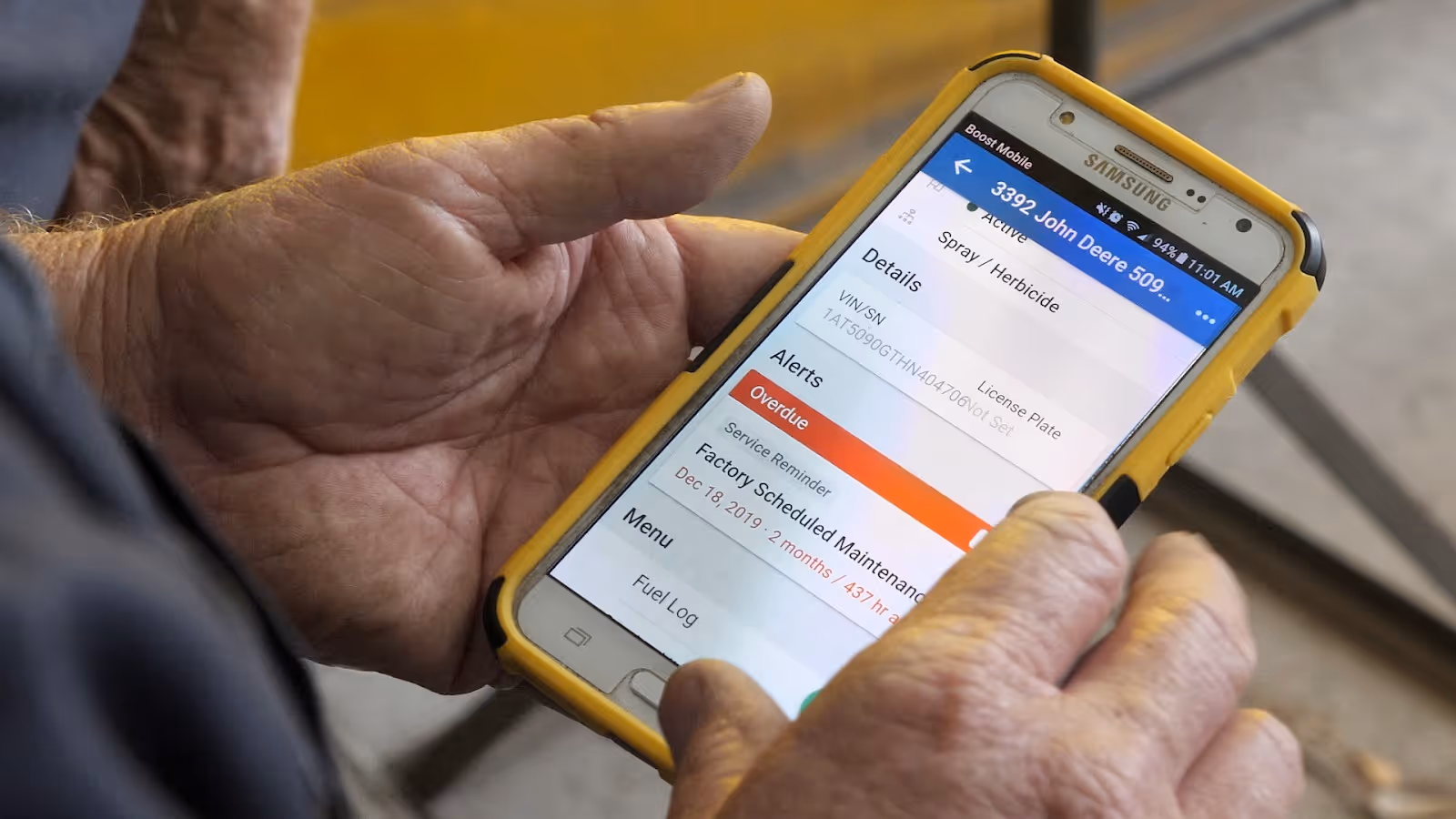 An image of a man holding a yellow mobile phone