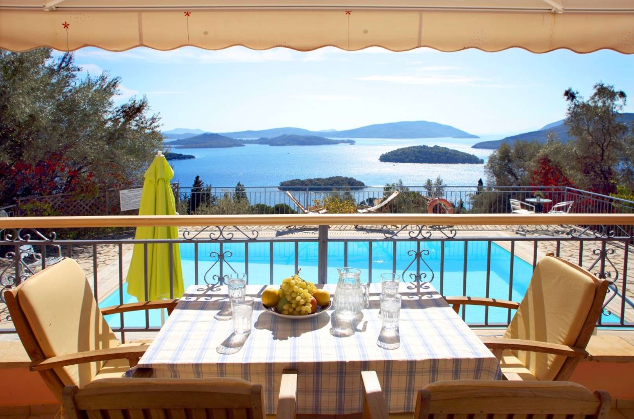 A summer holiday home with a view of the water with yachts and resorts in the background.